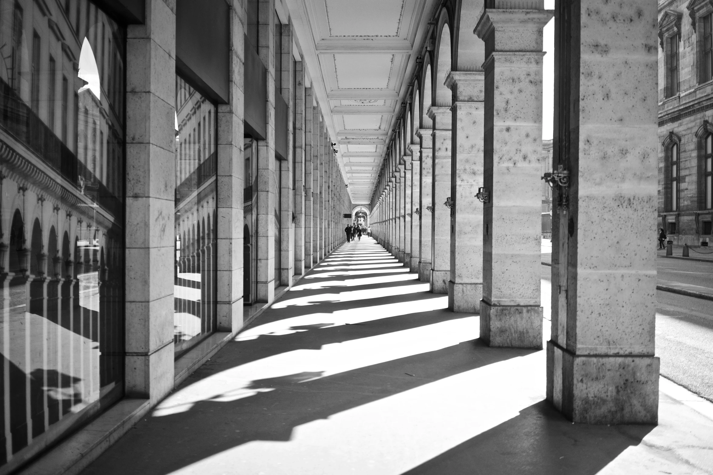 several pillars on an outside sidewalk near an empty street