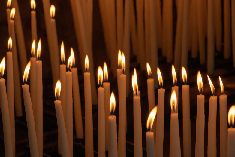 a number of lit candles with lots of them