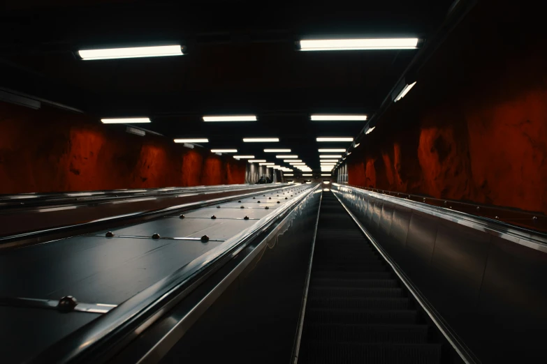 a dark po of an escalator in a public transit