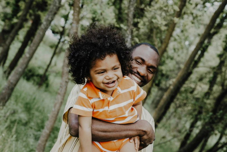 a man smiles as he holds his child