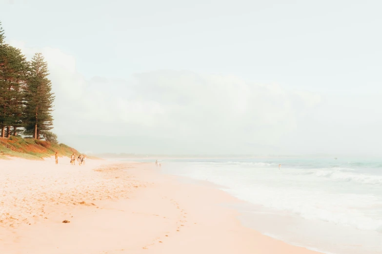 some people standing in the sand on the beach