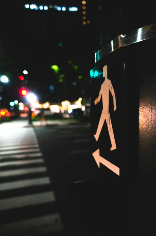 the person is walking on a crosswalk, and the lights of some buildings glow brightly in the distance