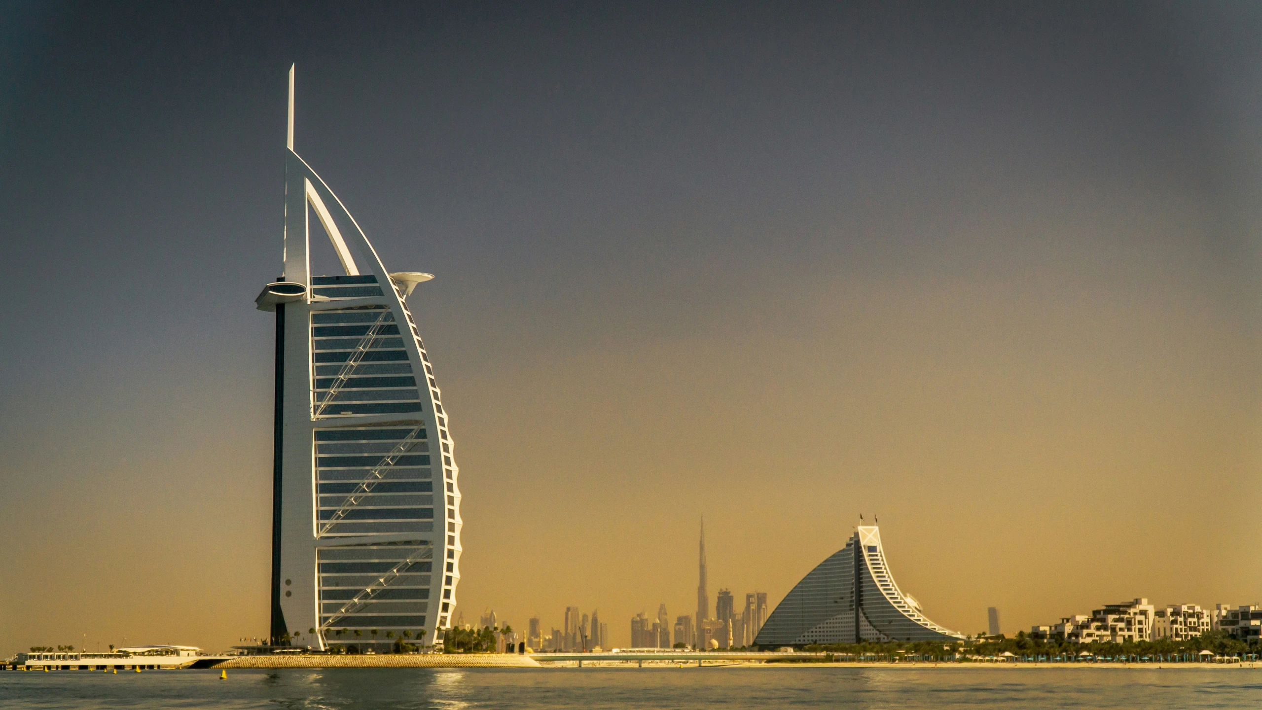 several tall buildings on the water next to each other