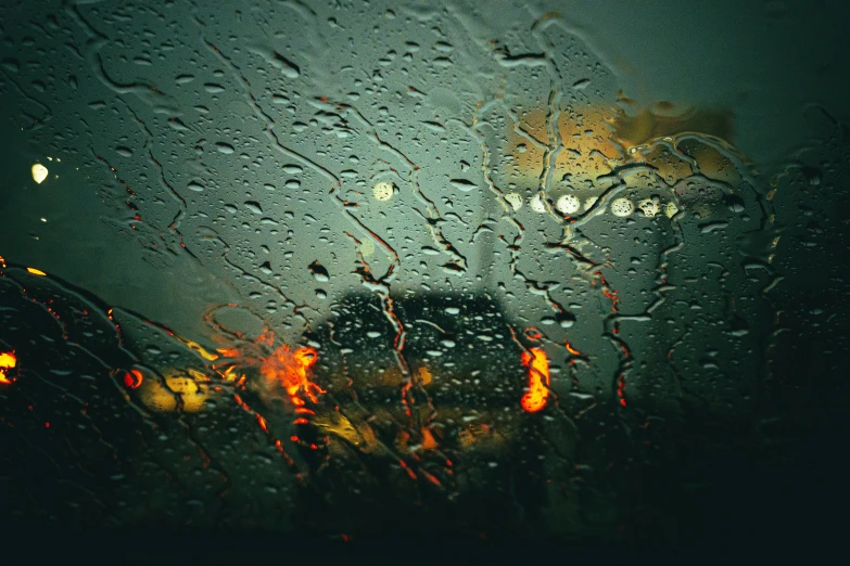 a rain covered window with a view of a tree and building