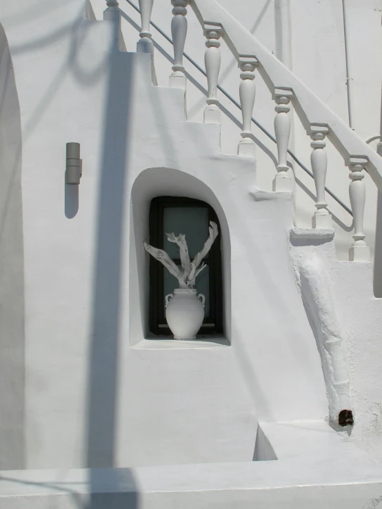 the staircase is decorated with white vases and a sculpture