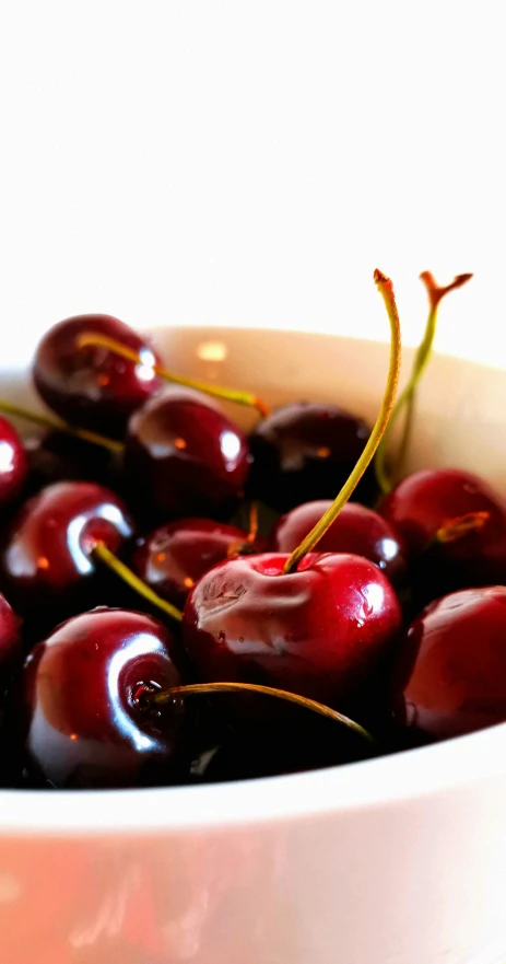 a white bowl filled with lots of cherries