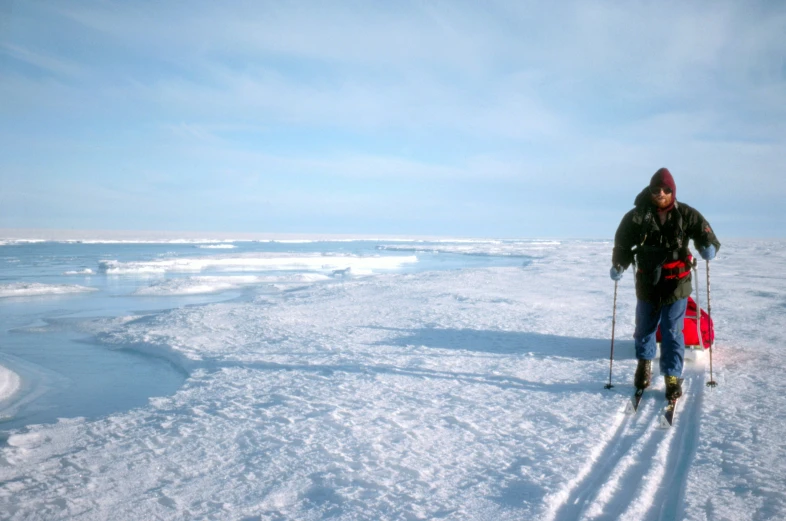 a man cross country skiing on an icy sea