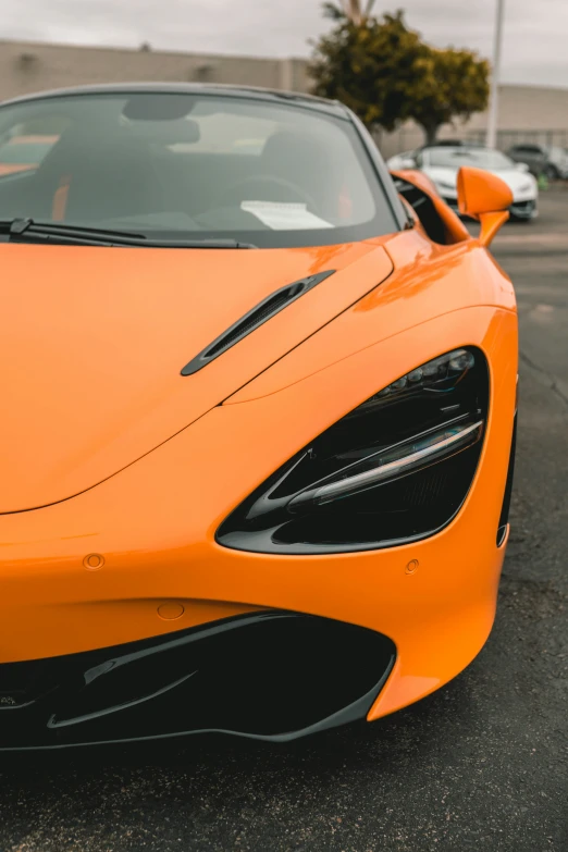 there is a orange sports car parked next to another