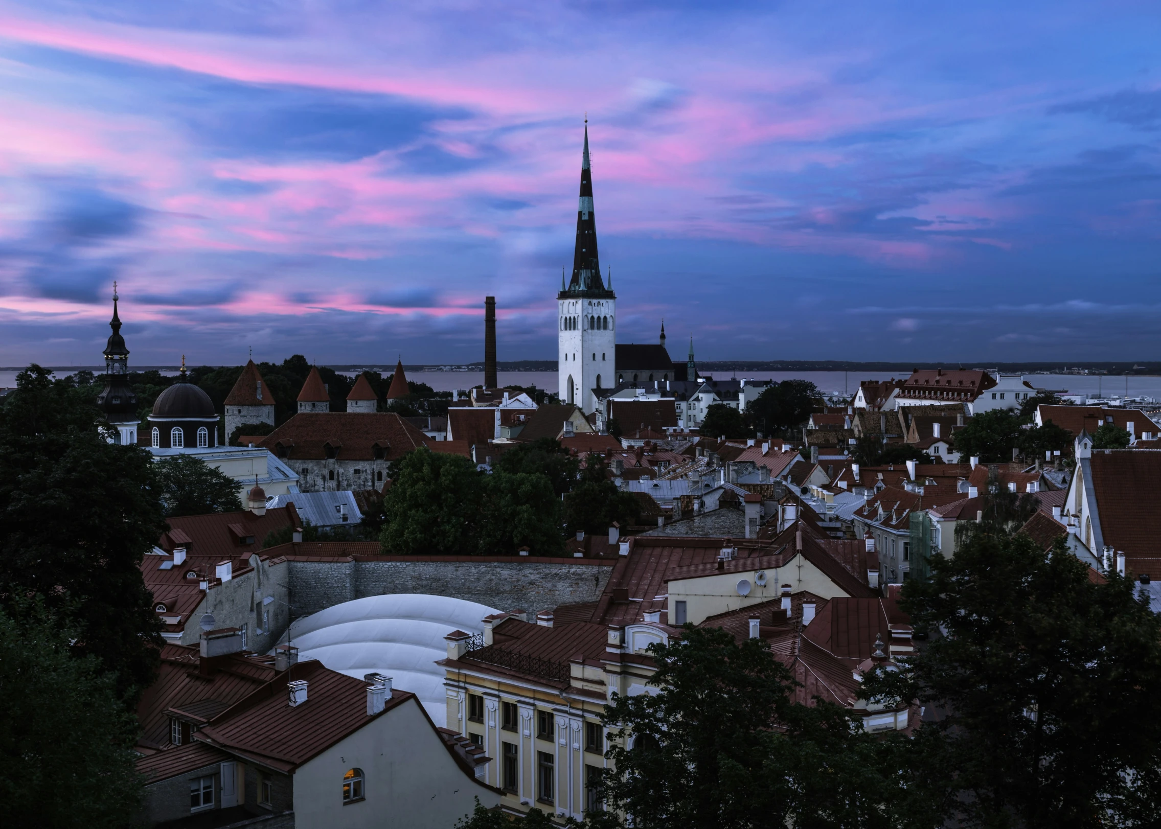 a city skyline during sunset with red rooftops