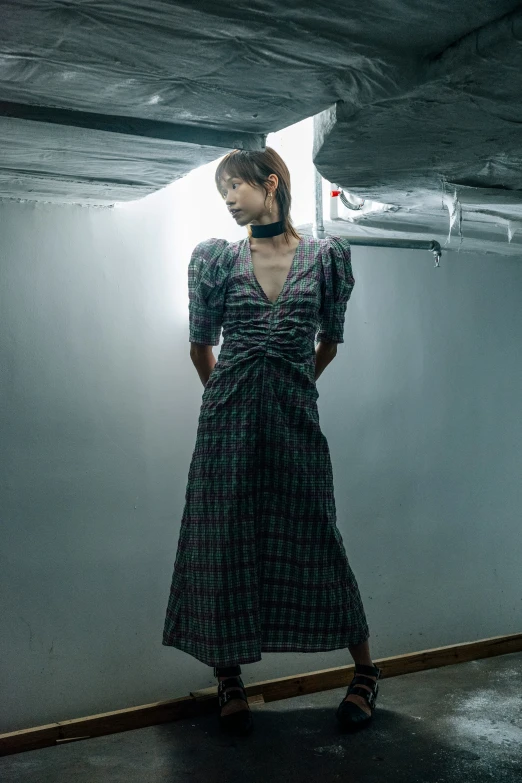 a woman in black and white dress looking down under a ceiling