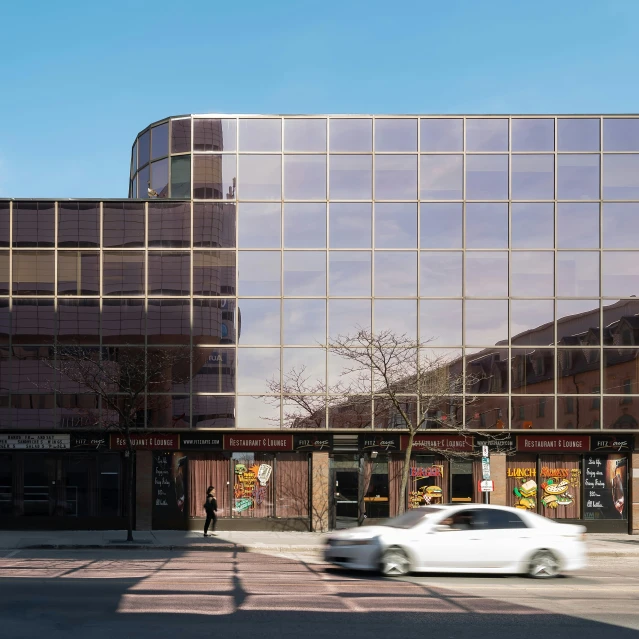 a car is parked in front of glass buildings