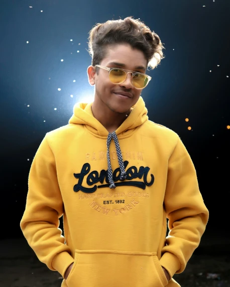 a man with a blonde bun in a yellow sweat shirt with sunglasses on