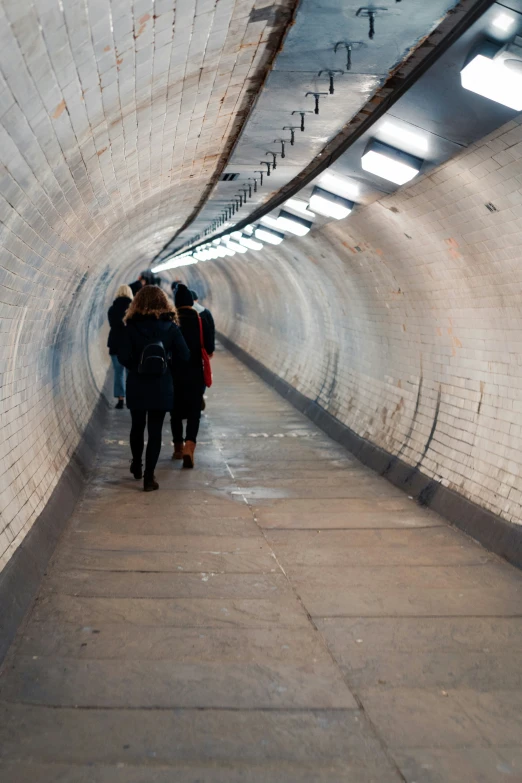 a group of people walking down a tunnel