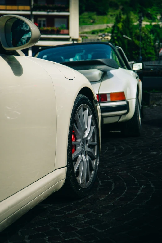 a white sports car is parked next to another silver car