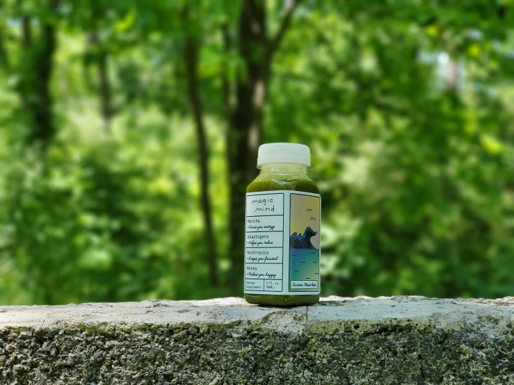 a bottle of liquid sits on a moss covered rock