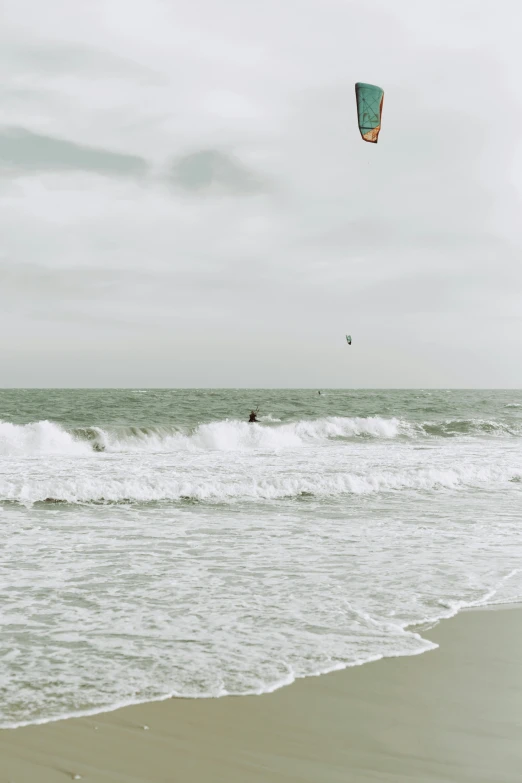 the person is parasailing in the ocean on a cloudy day