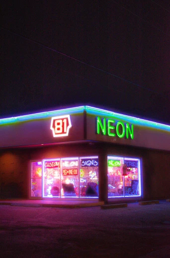 neon signs in store windows lit up at night
