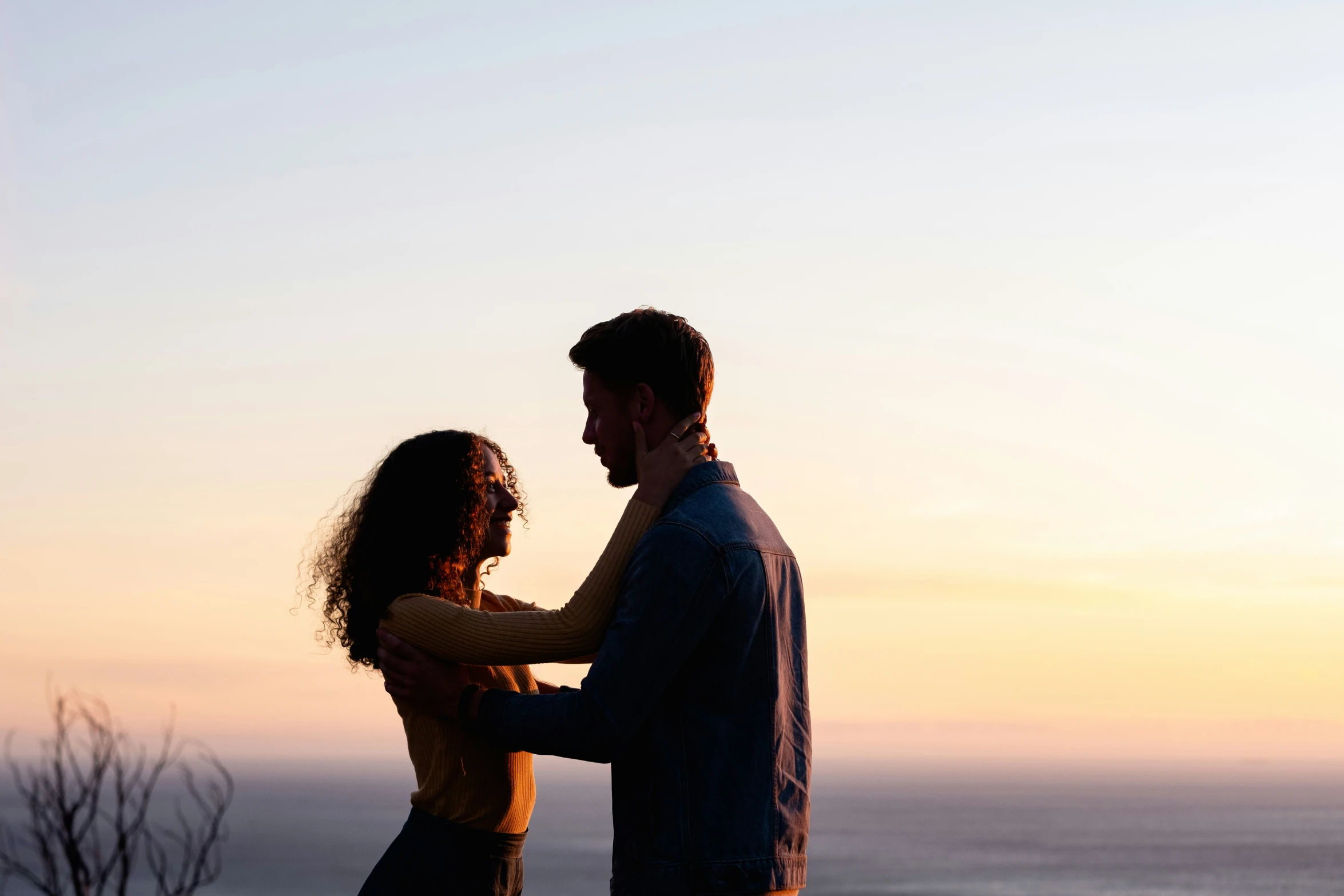 man and woman emcing in front of an incredible sunset