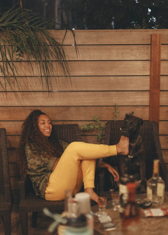 a woman is petting a dog sitting on a couch