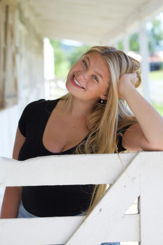 a woman posing on the side of a fence