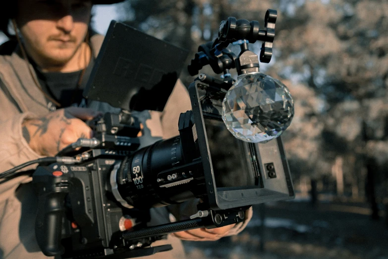 a man with a hat holds a camera in his hand