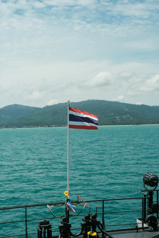 a view of the ocean from a ship with a flag on the mast