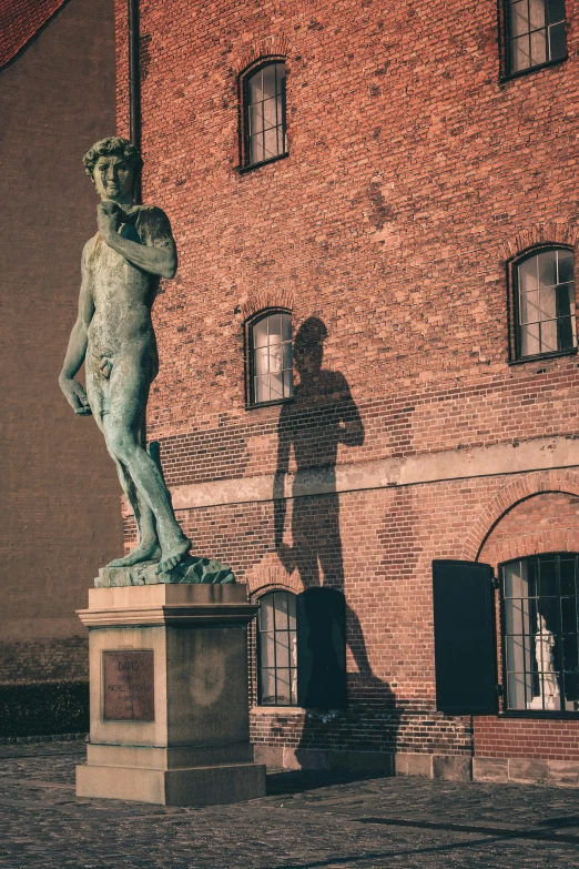 the man standing behind the sculpture is casting a shadow on it