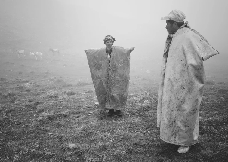 two men in the fog standing next to each other