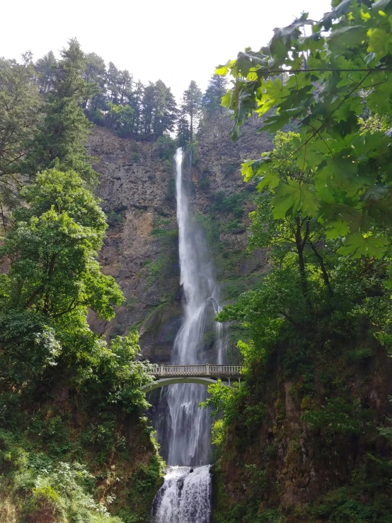 a waterfall is shown, with a small bridge leading to it