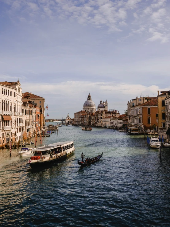 boats floating on the water in a canal with buildings around