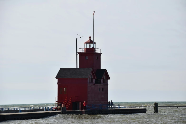 there is a lighthouse on a pier with waves in the water