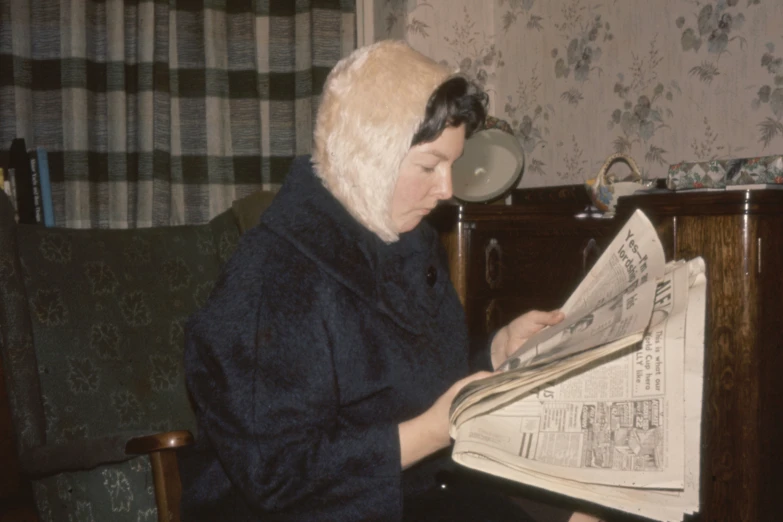 a woman reading an old fashioned newspaper in a chair