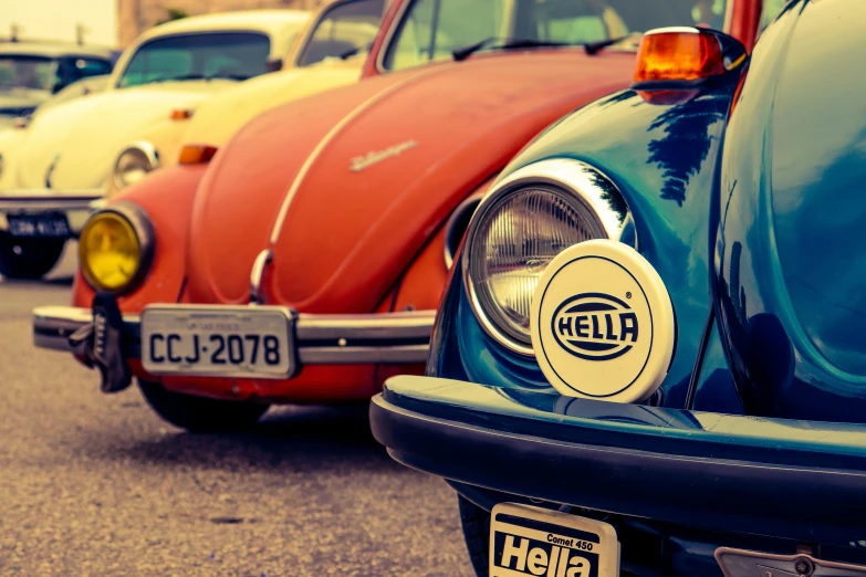 row of vintage vw beetle cars sitting parked in a lot