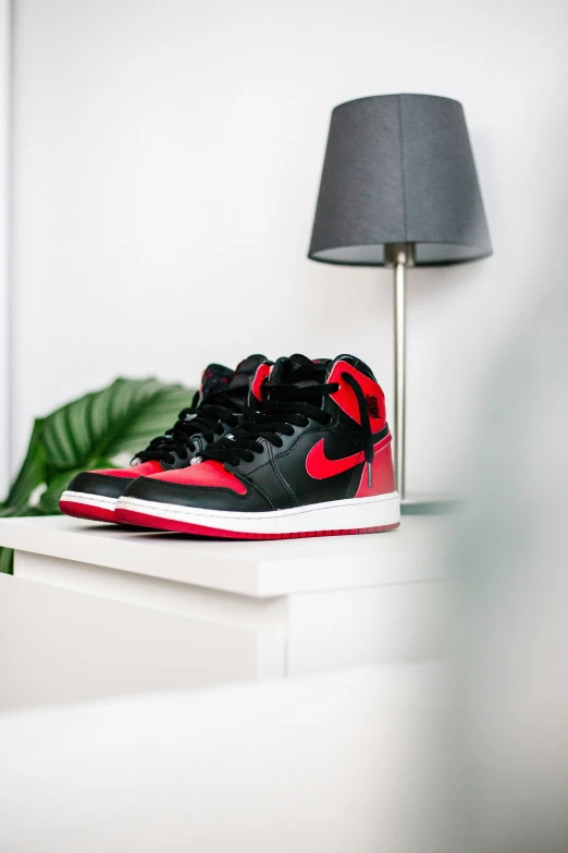 a pair of jordan shoes sit on a shelf with a lamp in the corner