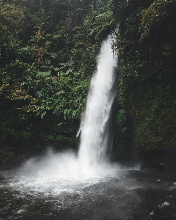 a waterfall falling down into a small body of water