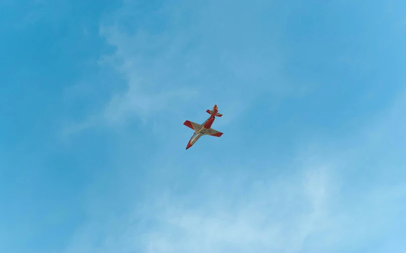 an airplane flying through the sky on a sunny day