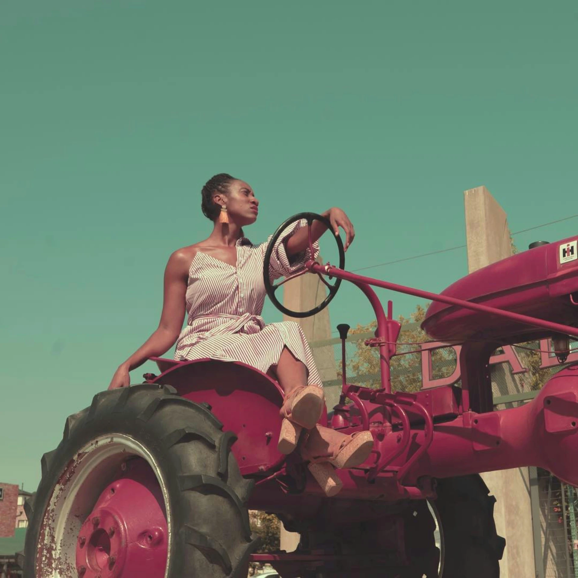 woman sitting on a red farm tractor with a steering