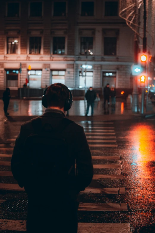 a person standing in the rain with headphones