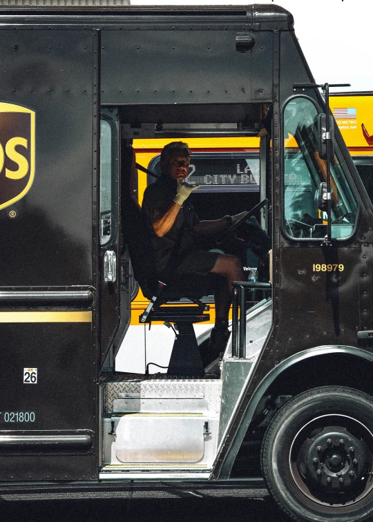 a woman sits in the driver seat of a yellow and black truck
