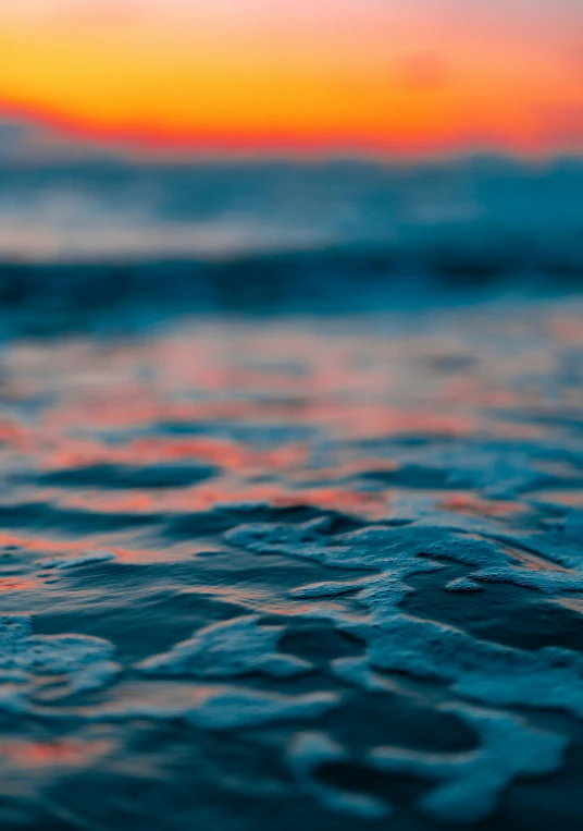 sunset over the ocean with very small waves