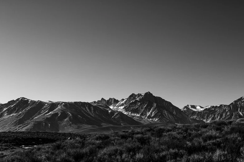 a clear sky over snow capped mountain tops