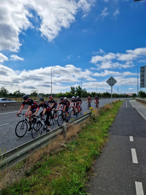 several people riding their bikes on a paved road