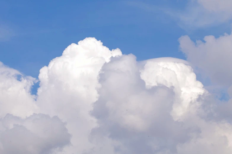 an airplane flying through a very large cloudy sky