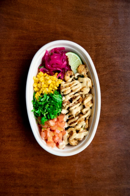 the bowl contains several different vegetables and chicken