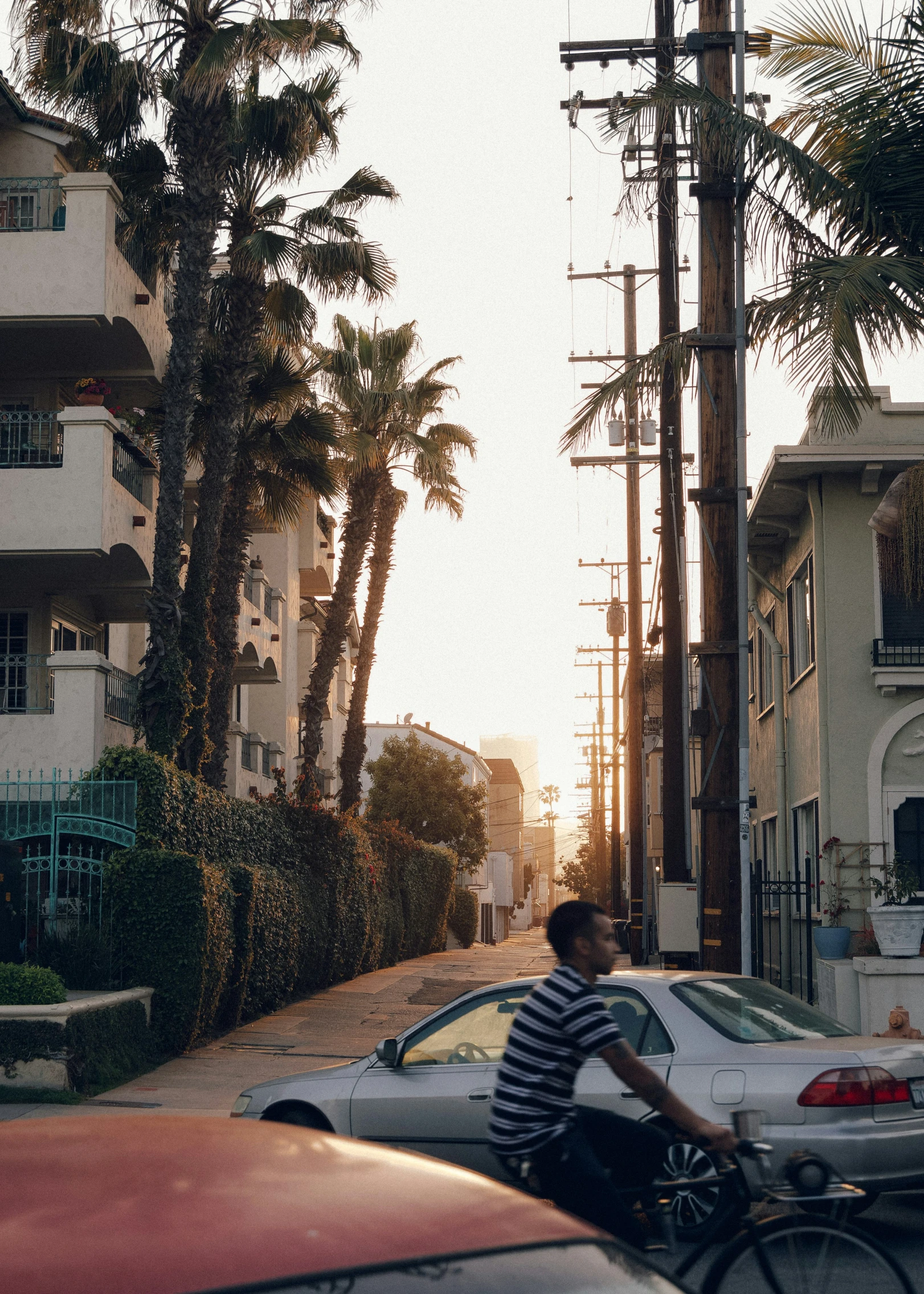 a man riding his bicycle on the street next to some buildings