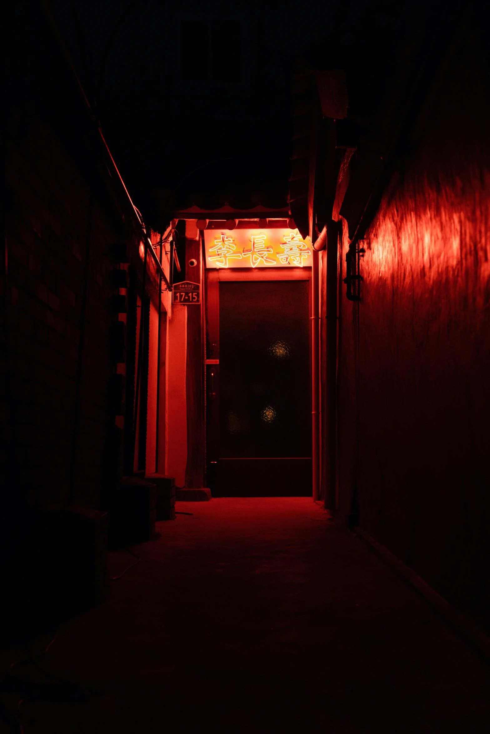 a doorway that is lit up at night with the lights on