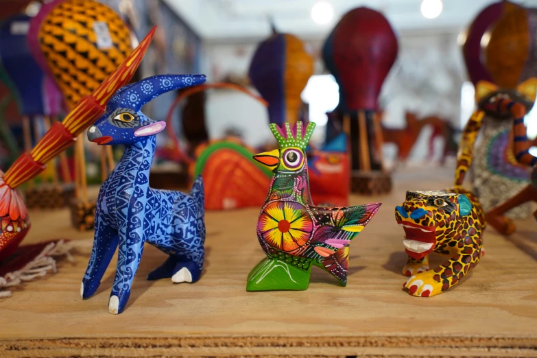 several small figurines are sitting in front of colorfully colored glass sculptures