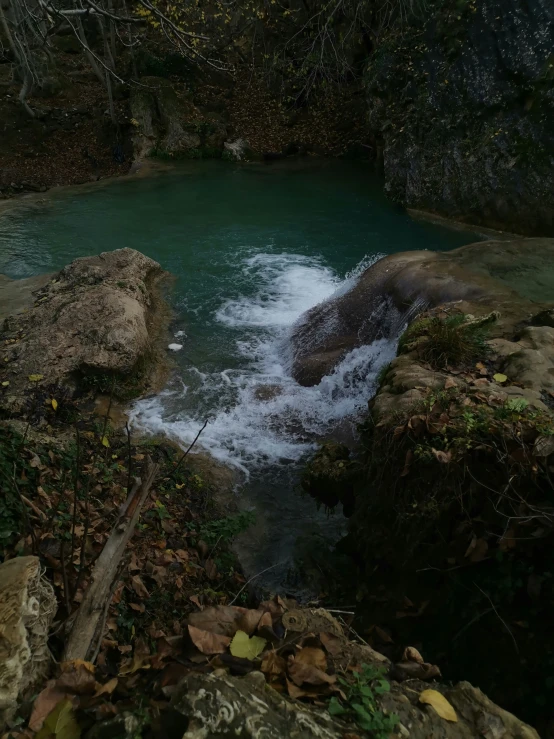 a river flows through the ground surrounded by moss and rocks