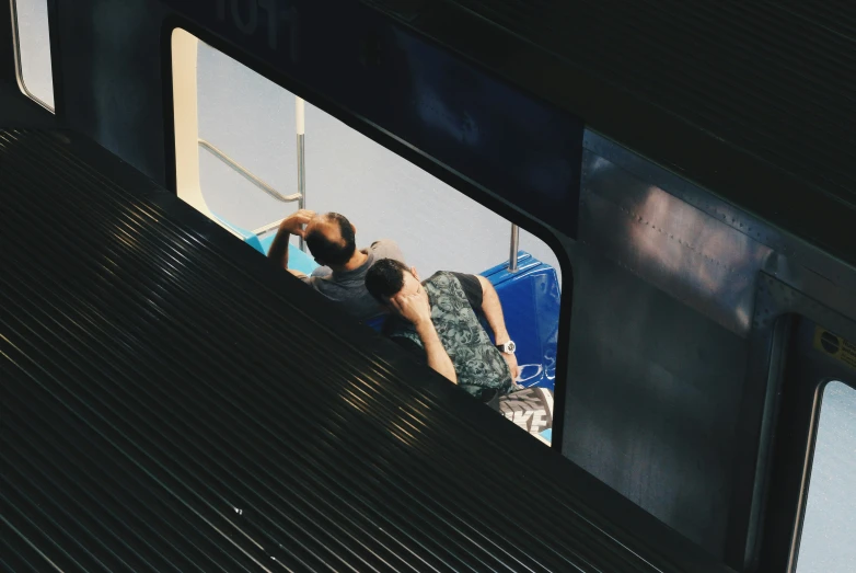 a woman is sitting in the window of a subway train