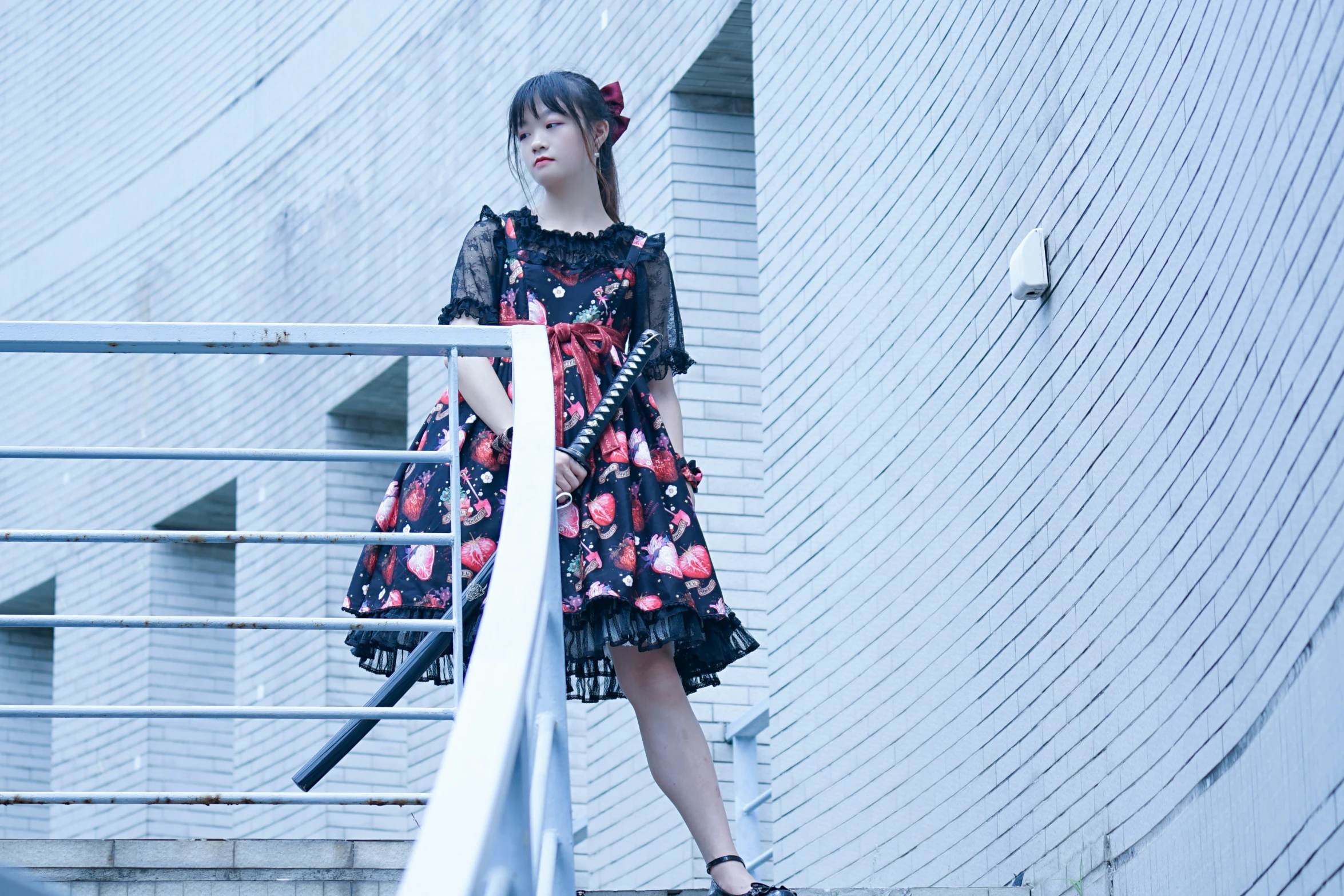 girl in dress leaning against stair railing and staring away